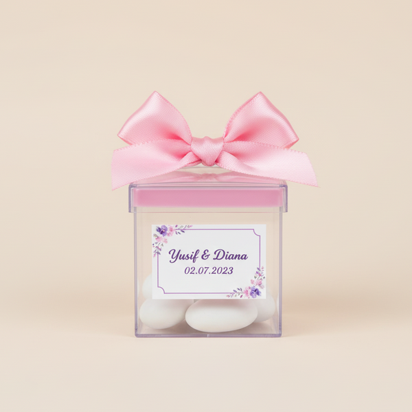 Drajee chocolate in a transparent box with a pink bow and personalized label on a beige background