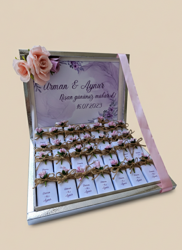 Personalized chocolate box with floral decorations and engraved text on a beige background
