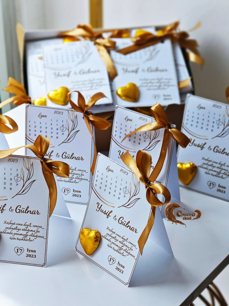 Calendar cards with gold ribbons and decorative elements on a white surface