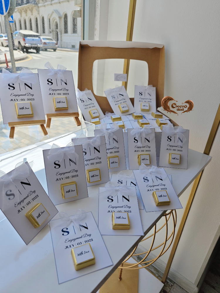 Gold and white jewelry display with 'SIN' branding on a table.