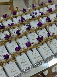 White chocolate bars with gold text and purple flowers on a marble surface