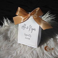 Elegant and customizable, these boxes are the perfect keepsake for your engagement or ring ceremony celebrations!

#EngagementFavors #GoldRibbonElegance #CustomChocolates