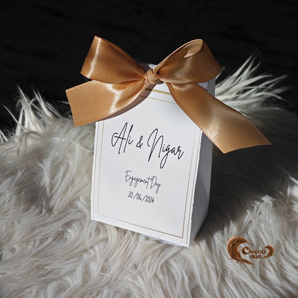 Elegant and customizable, these boxes are the perfect keepsake for your engagement or ring ceremony celebrations!

#EngagementFavors #GoldRibbonElegance #CustomChocolates