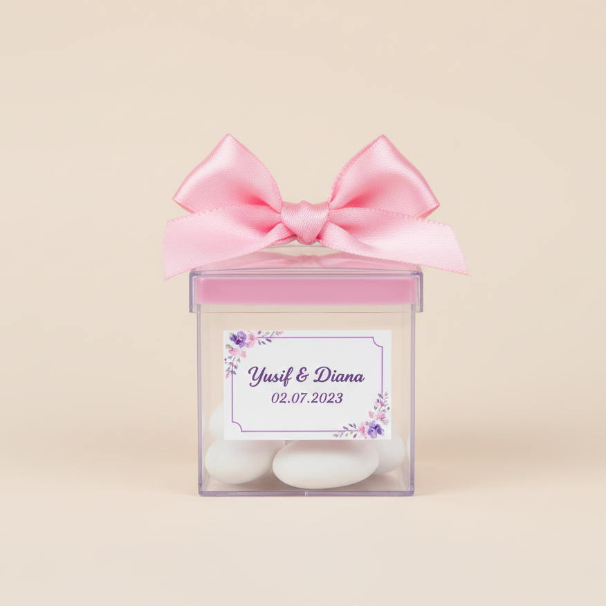 Drajee chocolate in a transparent box with a pink bow and personalized label on a beige background