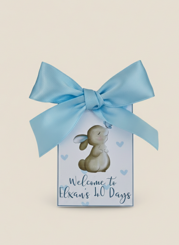 Gift box with a blue ribbon and a bunny illustration on a beige background