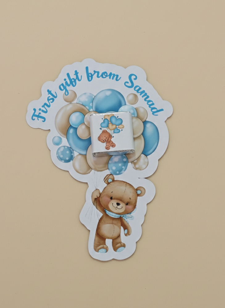 Sticker with teddy bear and text 'First gift from Samad' on a beige background