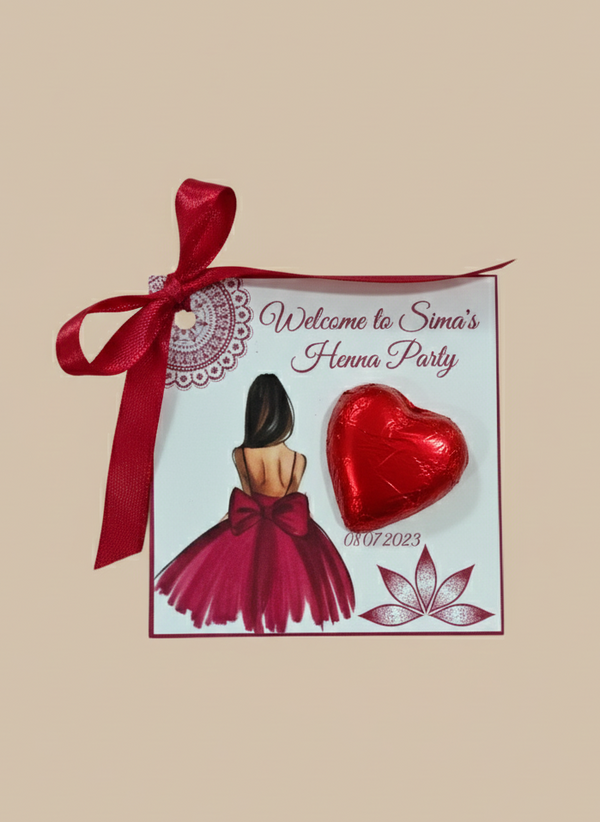 Henna party invitation with red ribbon, heart-shaped chocolate, and floral design on a beige background