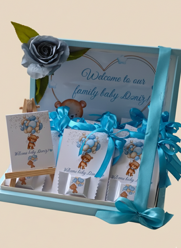 Baby gift set with teddy bear-themed cards and a rose on a beige background