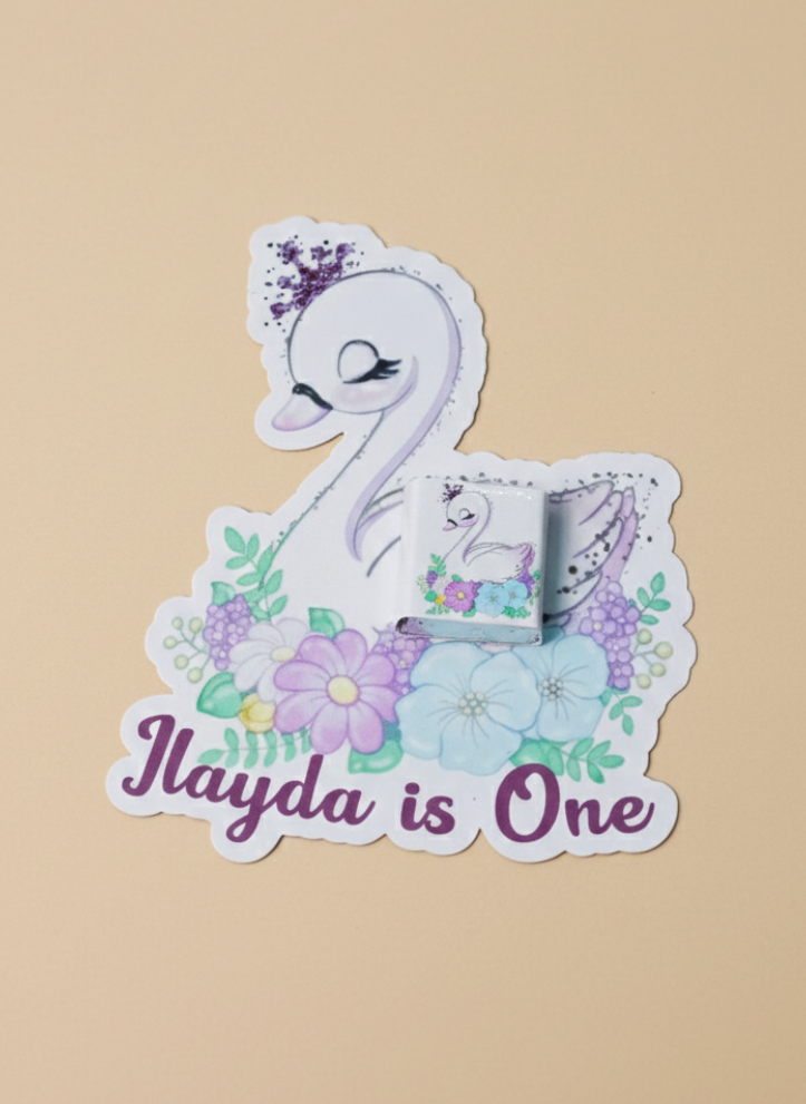 Sticker with a swan design and 'Ilayda is One' text on a beige background