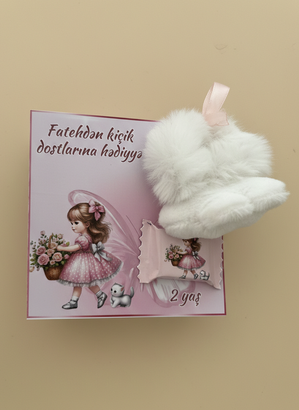 Small plush toy with white fur on a pink card with graphics and text, against a beige background