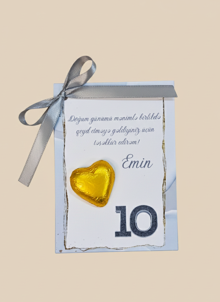 Gift box with a gold heart and ribbon on a beige background
