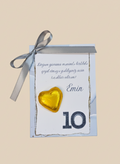 Gift box with a gold heart and ribbon on a beige background