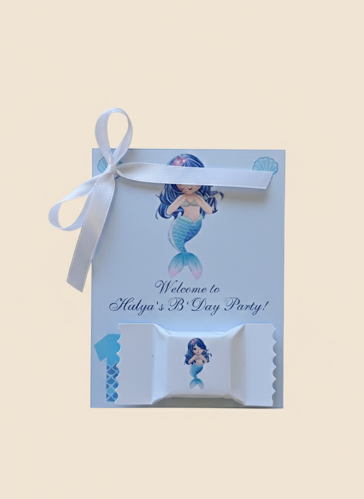 Mermaid-themed party favor box with ribbon on a beige background