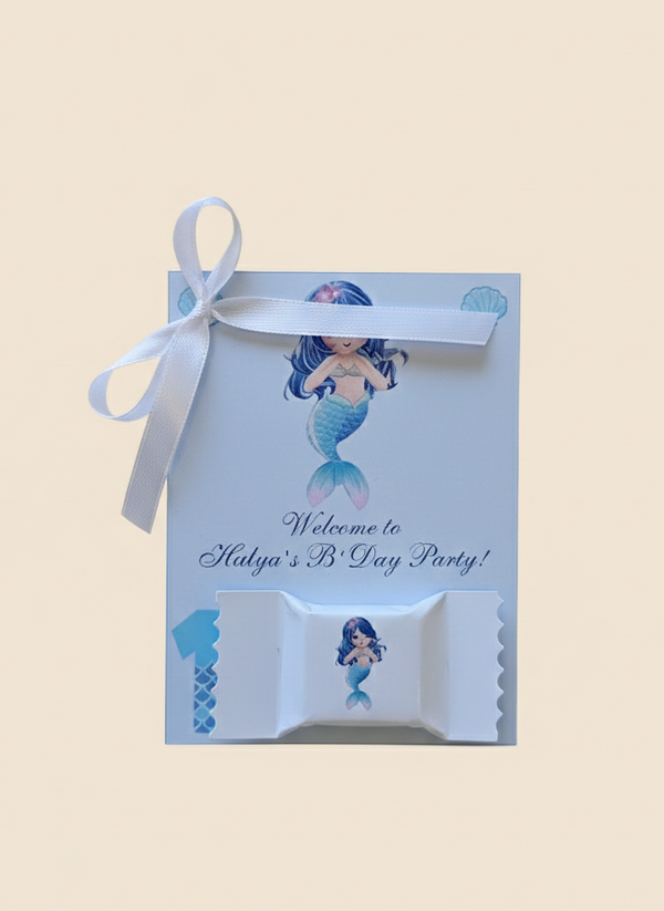 Mermaid-themed party favor box with ribbon on a beige background