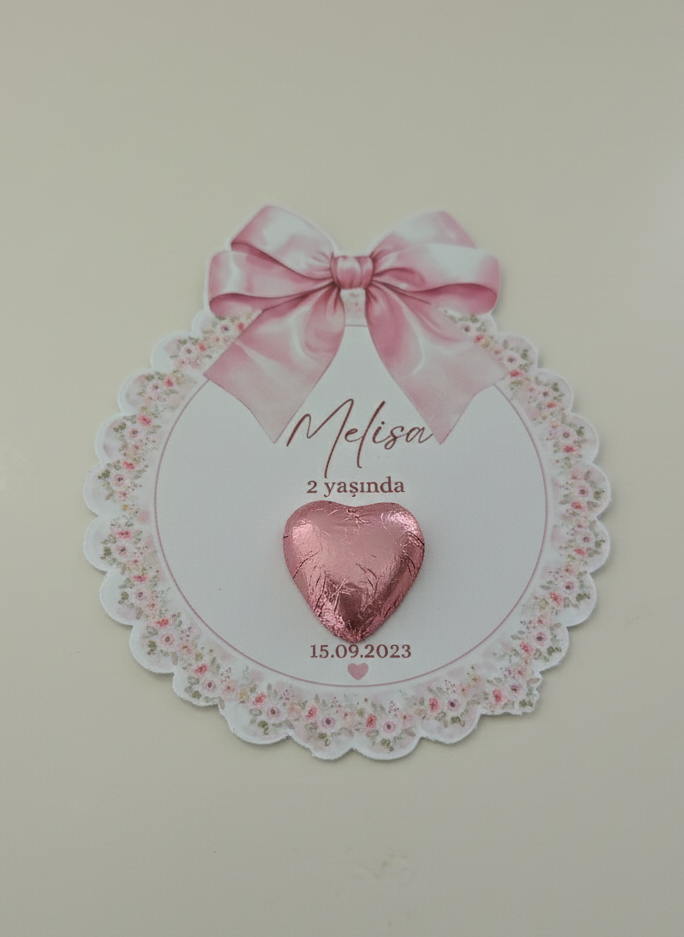 Pink heart-shaped object on a decorative card with a bow on a beige background
