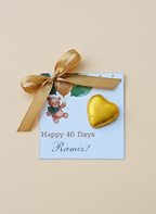 Greeting card with teddy bear, gold heart, and ribbon on a beige background