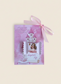 Pink gift box with castle design and bow on a beige background