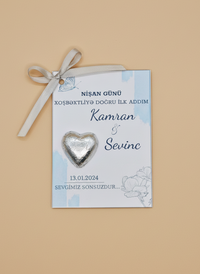 engagement invitation with heart-shaped decoration on a beige background and chocolate