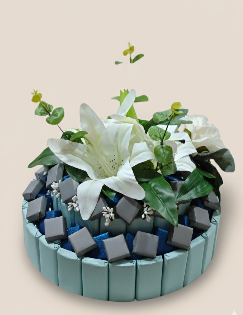 Decorative arrangement with white flowers, green leaves, and gray stones on a beige background