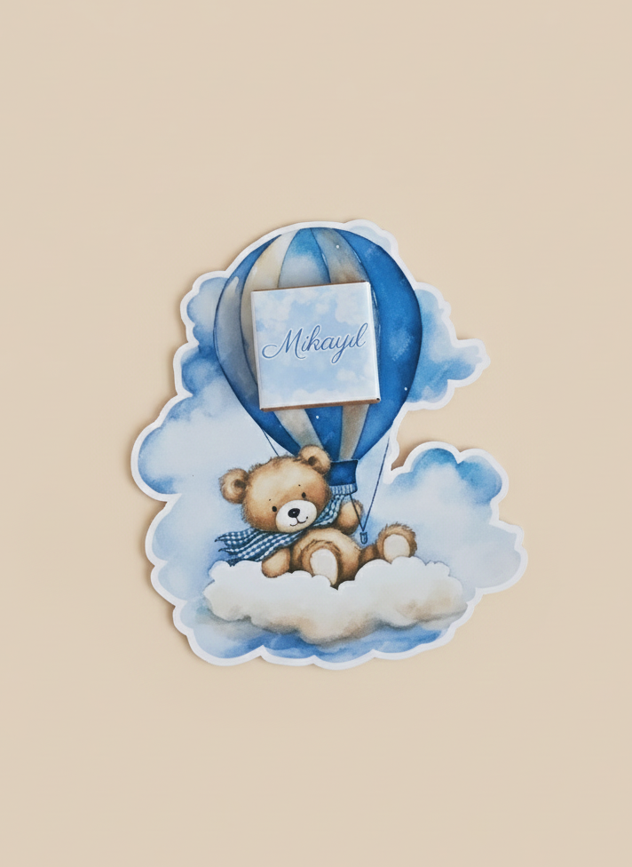 Sticker of a teddy bear in a hot air balloon with a blue ribbon on a beige background