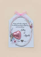 Invitation card with floral design and heart-shaped chocolate on a beige background