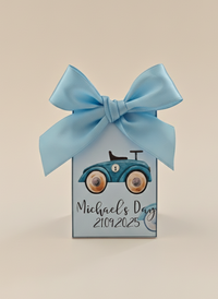 Gift box with blue ribbon and vintage car design on a beige background