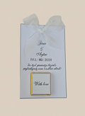 Wedding invitation card with text and a gold frame on a light blue background