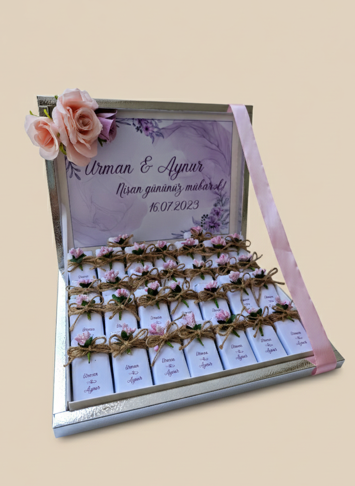 Personalized chocolate box with floral decorations and engraved text on a beige background