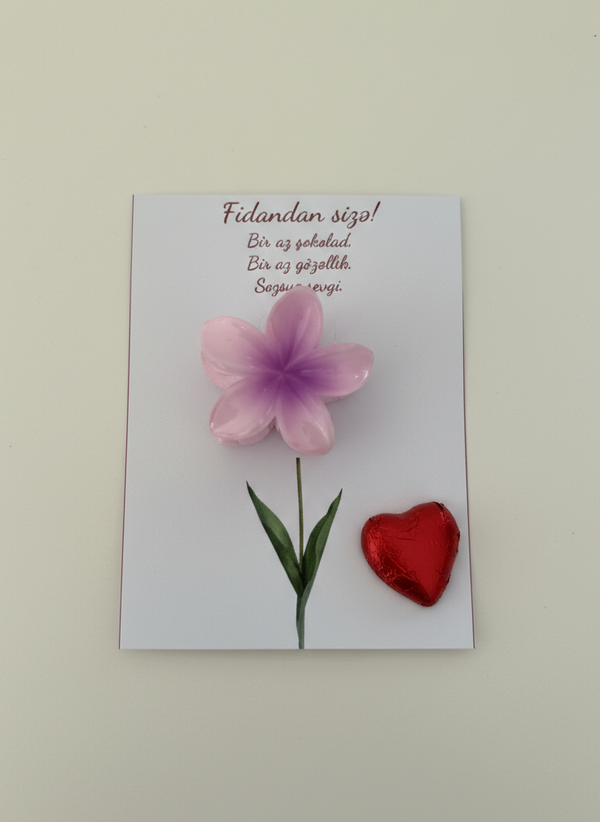 Card with a pink flower and red heart on a light gray background