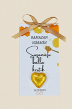 Decorative card with gold heart, ribbon, and text on a beige background