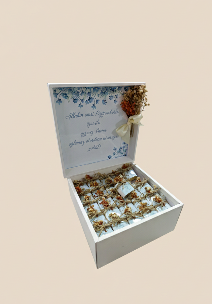 Gift box with flowers and a card on a beige background