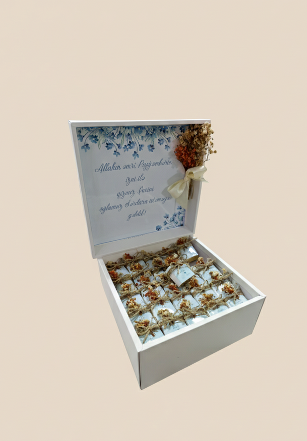 Gift box with flowers and a card on a beige background