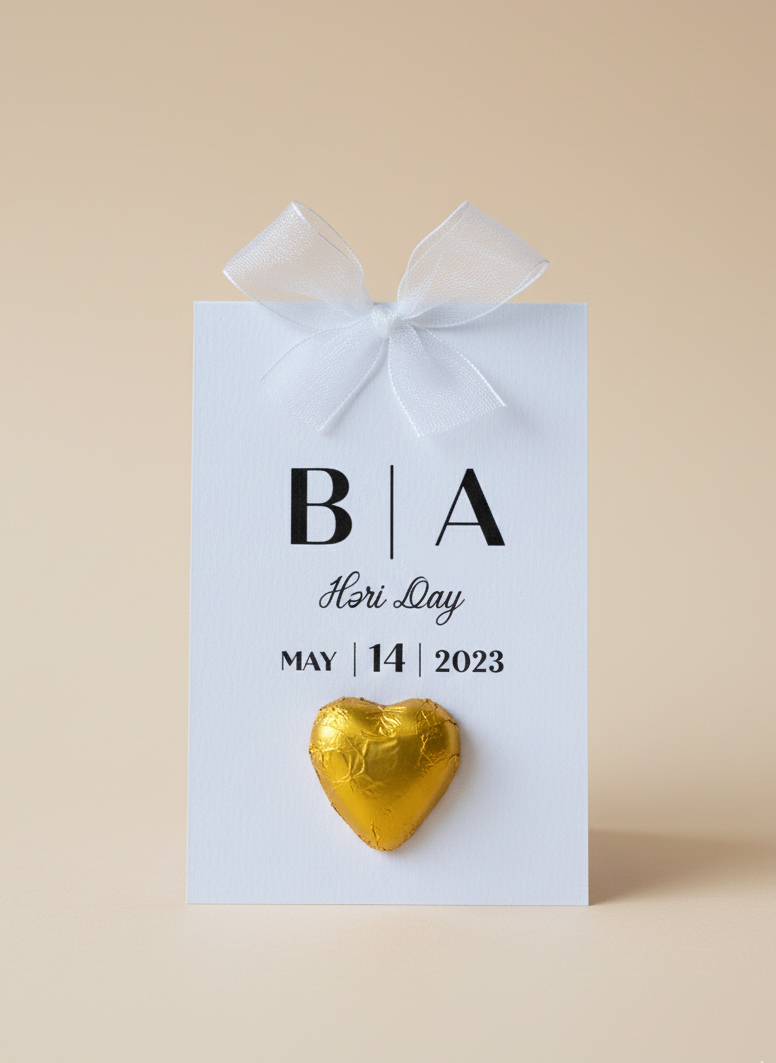 Gold heart-shaped chocolate on a white card with 'BA Hari Day' text on a beige background