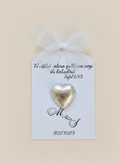 Gold heart-shaped chocolate on a card with personalized text on a beige background