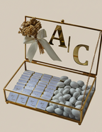 Decorative box with 'A/C' initials, flowers, and small chocolates on a beige background