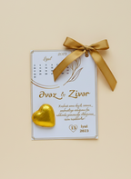 Calendar with gold ribbon and chocolate heart on a beige background