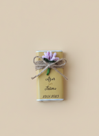 Small rectangular chocolate gift box with floral decoration and string on a beige background