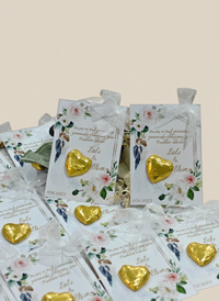 Gold heart-shaped chocolates on floral card packaging with text