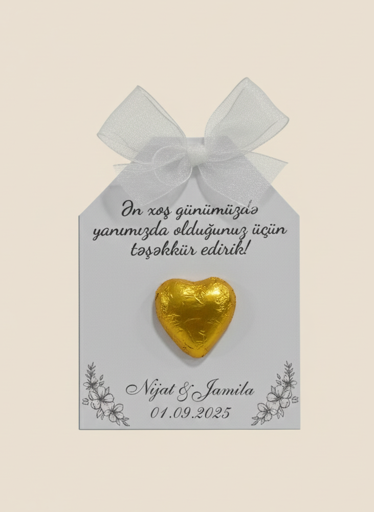 Gold heart-shaped chocolate on a decorative card with text and a bow.