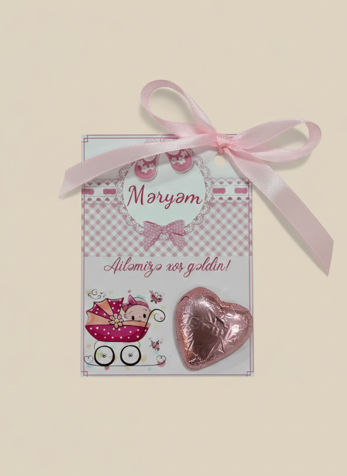 Card with pink heart-shaped chocolate and ribbon on a beige background