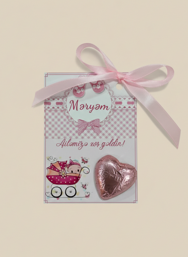 Card with pink heart-shaped chocolate and ribbon on a beige background