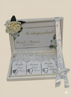 Decorative box with heart-shaped name cards and floral elements on a beige background