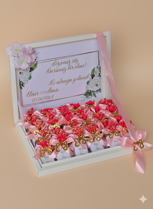 Gift box with pink ribbons and flowers on a beige background
