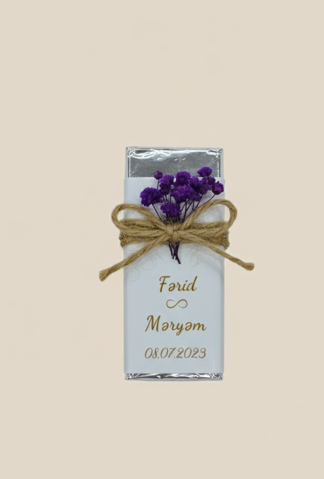 Small rectangular container with purple flowers tied with twine on a beige background