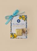 Decorative card with gold box and blue ribbon on a beige background