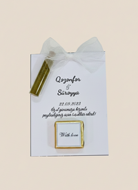 Gold ring box with a card on a beige background