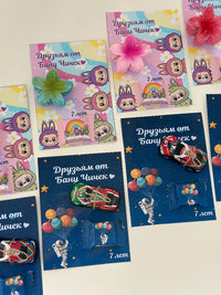 Colorful cards with cartoon characters and small toys on a white background