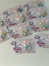 Set of cards with cartoon bunny designs and small decorative items on a light background