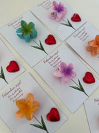 Colorful flower-shaped objects on cards with text on a white surface