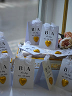 Decorative boxes with 'B/A' initials and gold hearts on a table.